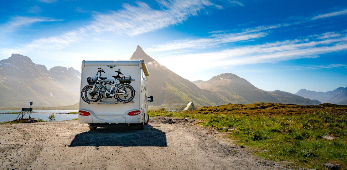 Camper steht auf einem Campingplatz in den Bergen in der Nähe eines Bergsees