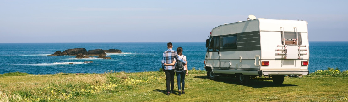 Die Familie fährt mit dem Wohnmobil in den Urlaub und sucht einen Campingplatz mit Meerblick.