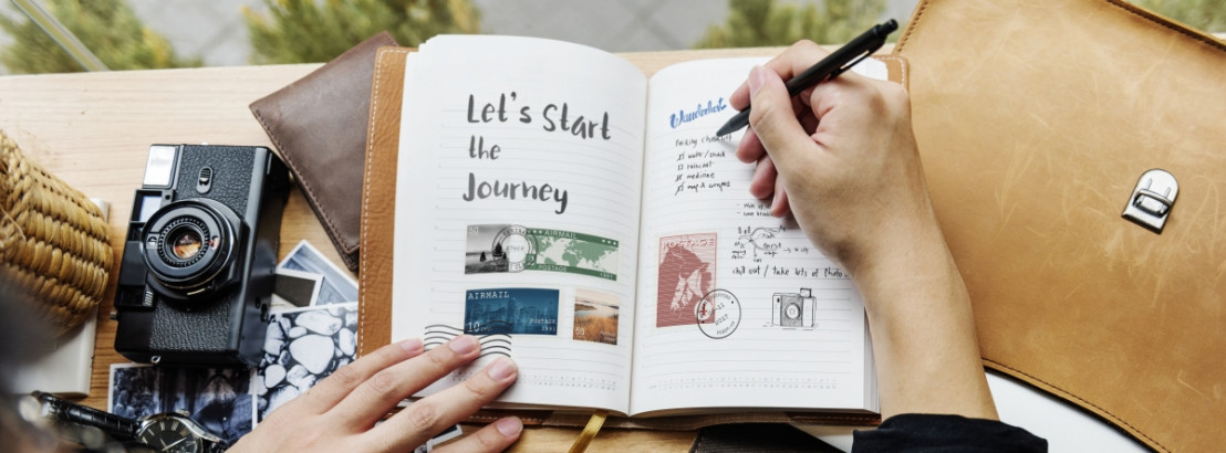 Offenes Reisetagebuch mit Fotos, Stickern und handgeschriebenen Notizen."