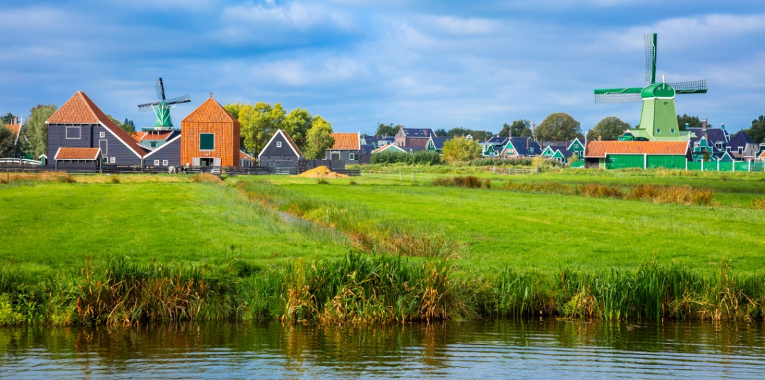 Typisch niederländisches Bild mit Mühlen und alten Häusern auf dem Land im Polder.