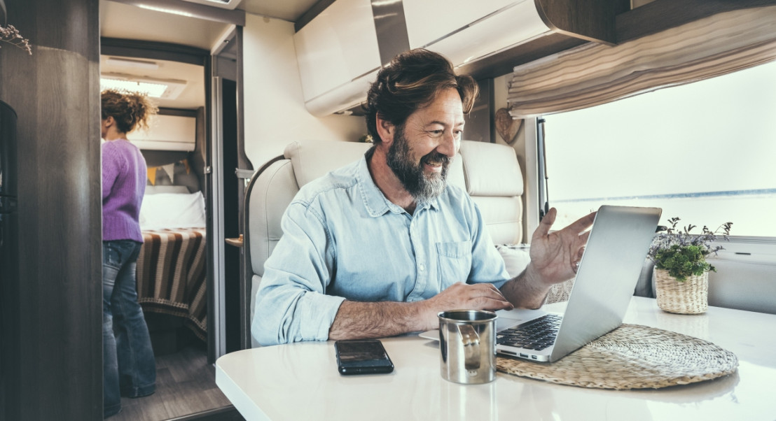 Flexibel arbeiten: Mann genießt die Freiheit, von überall aus zu arbeiten - im Camper.