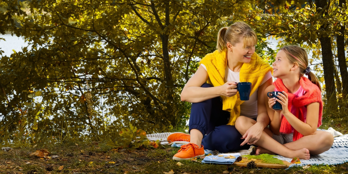 Die Frau trinkt mit ihrer Tochter eine Tasse Kaffee auf einem Campingplatz während der Camperreise